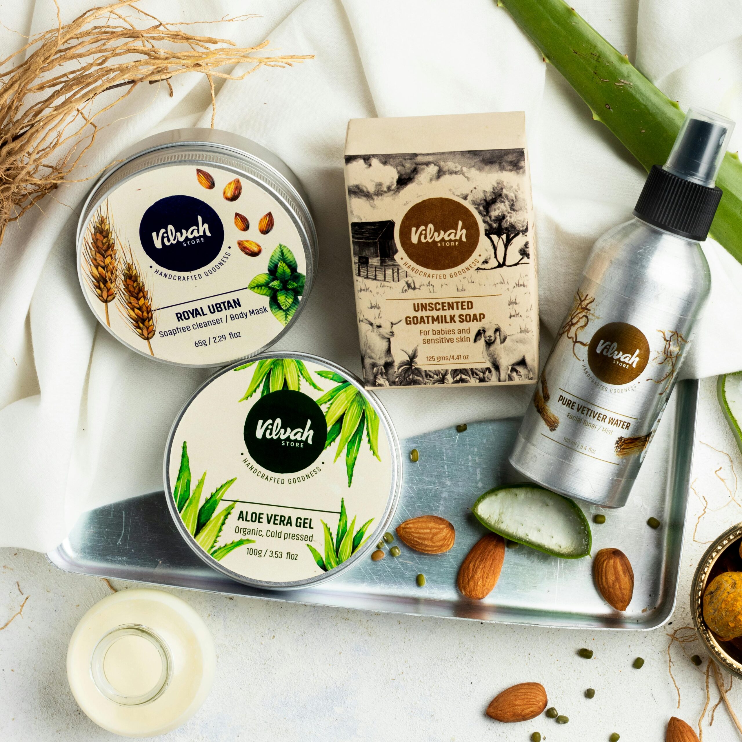 Top view of Vilvah organic skincare products including soap, gel, and water on a white background.